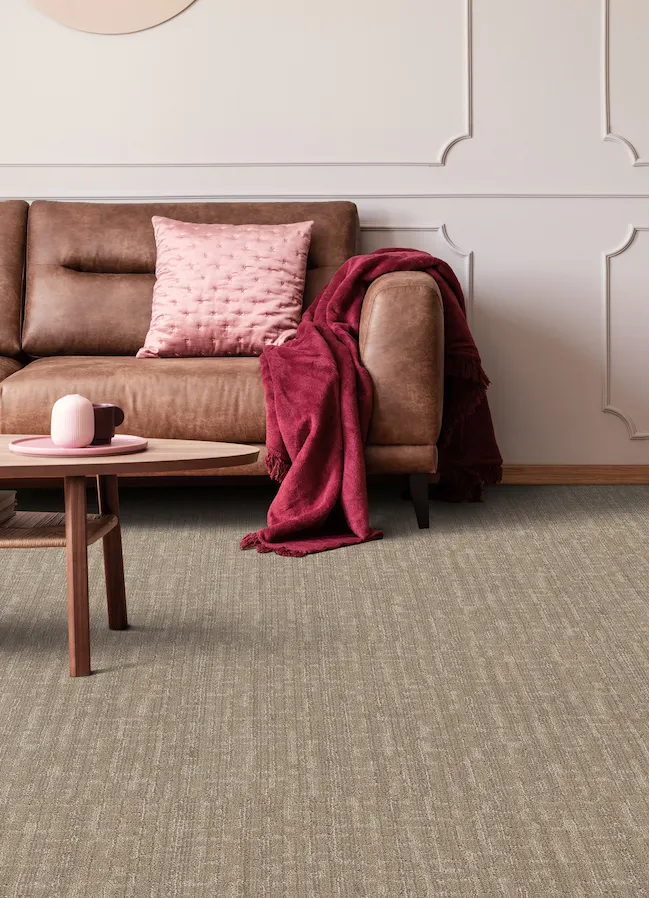 brown textured carpets in a living room with a leather couch and pink accents