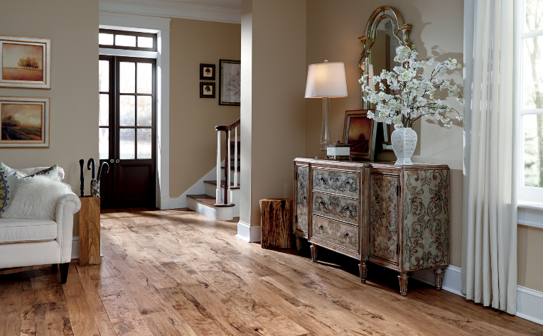 warm toned hardwood flooring in living room with white couch and natural decor.